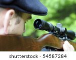 Man looking through the scope on his wooden rifle gun