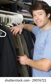 Man Looking Through Shirts In His Closet