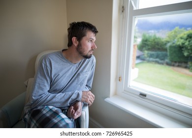 Man looking through the window at home