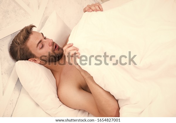 Man looking under blanket. Morning wood formally\
known nocturnal penile tumescence common occurrence. Male\
reproductive system. Why men get morning erections. Normal\
erections occur. Guy relax in\
bed.
