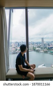 Man looking at the view from window on a cloudy day