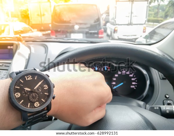 The Man looking watch with hand\
driving car on the traffic jam , digital effect\
sunlight