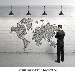 Man Looking At  World Map On Brick Wall