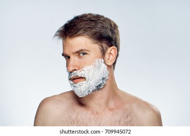 man looks at the camera on his beard foam on a light background portrait, beauty                                - Powered by Shutterstock