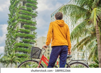 Man Looks At Eco Architecture. Green Cafe With Hydroponic Plants On The Facade. Ecology And Green Living In City, Urban Environment Concept. Modern Building Covered Green Plant