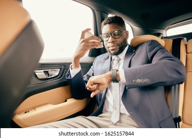 Man Looks At His Apple Watch While Being In The Car.