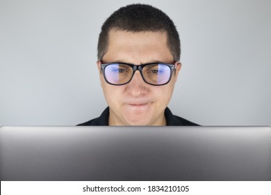 The Man Looks At The Laptop, Gets Angry And Annoyed About What He Saw There. Expressing Emotions And Reacting To What You See On The Internet. Shocking Content Concept.