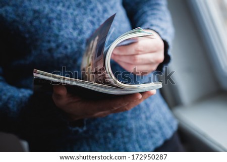 A man looks at a magazine. Press hands.