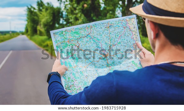 A man looks at a map on the road. Selective\
focus. Nature.