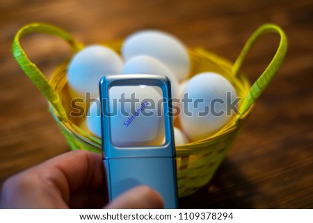 A man looks at some eggs in a basket and discovers an egg with salmonella