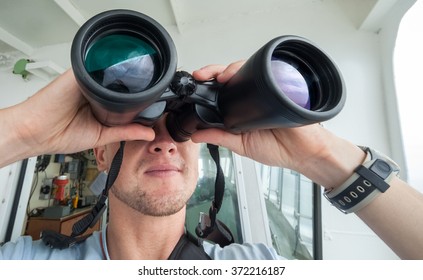 Man Looks Through Binoculars From The Boat