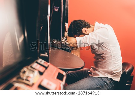 Man losing at slot machines in casino