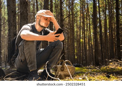 Man lost in the forest. Man looking at phone. No network on phone. Navigation. Emergency in the forest. Man calling for help - Powered by Shutterstock