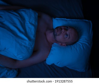 Man Lying In Bed, Stressed Cant Sleep Staring At The Ceiling. 