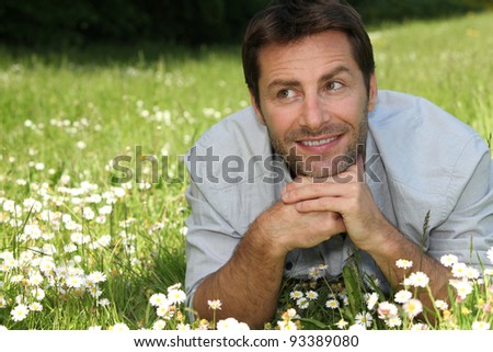 man lying in daisy field