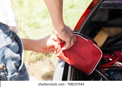 The Man Is Lying First-aid Kit In The Trunk Of The Car