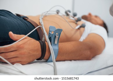 Man Lying On The Bed In The Clinic And Getting Electrocardiogram Test.