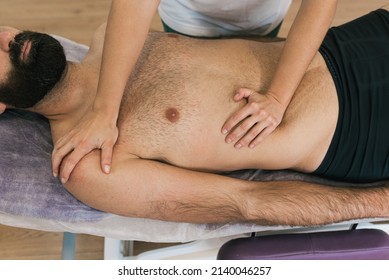 Man Lying On A Chiropractic Table Receiving A Massage By A Professional Therapist. Physiotherapy, Rehabilitation And Alternative Medicine Concept.