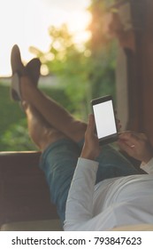 Man lying on a sofa and using cellphone.