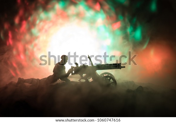 Man with Machine gun at night, fire explosion\
background or Military silhouettes fighting scene on war fog sky\
background, World War Soldiers Silhouettes Below Cloudy Skyline At\
night. Attack scene.