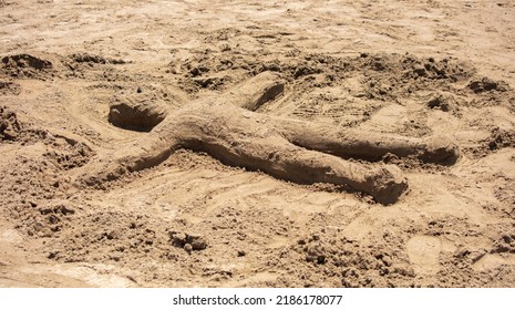 A Man Made Of Sand On The Beach By The Sea.