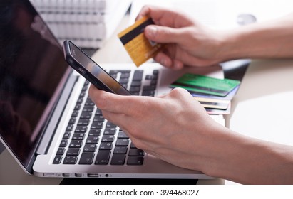 Man Make Electronic Payment Via Laptop Computer And Credit Card Sitting At The Glass Table With Books At The Background