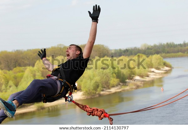 A man
makes an extreme jump from a bridge on a
rope.