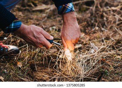 A man makes a fire with a flint - Powered by Shutterstock