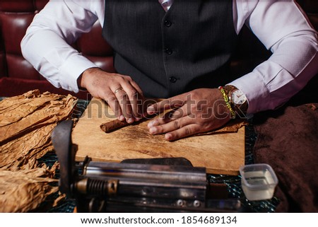 
a man makes a homemade cigar