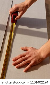 The Man Makes A Marking With Tape Measure On A Sheet Of Sound Proof Material, A Heater