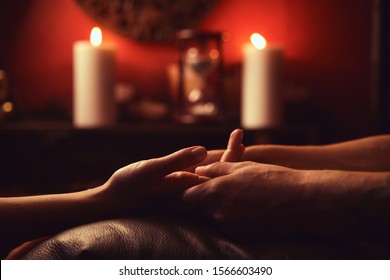 A man makes a woman acupressure fingers. hand massage with intimate lighting. Prelude before making love. Close. Complete relaxation.