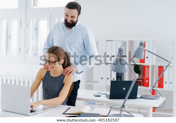 Man makes woman\
massage in the workplace