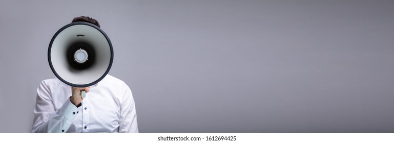 Man Making Announcement Using Megaphone Against Gray Background