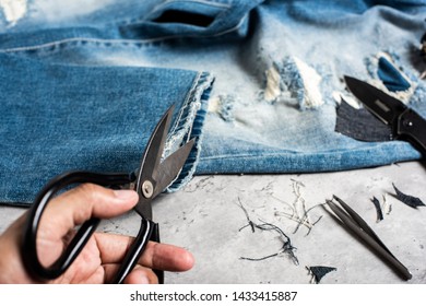 The Man Making Ditressed Jeans. DIY Ripped Jeans With Scissors And Razor.