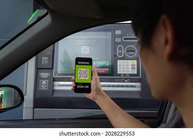 A Man Making Financial Transaction Via Online Platforms On A Car, Scan Banking QR Code With Phone. ATM Drive Through At Service Station. Cash Withdrawal. Convenience Urban Lifestyle. Self Service.