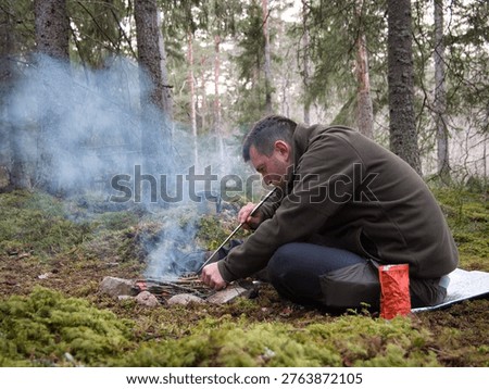 Man making fire in forest camping Sweden outdoor survival