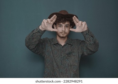 a man making frames from his hands for taking shots on camera            