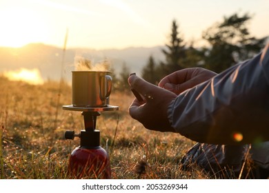 Man Making Hot Drink With Portable Gas Burner In Mountain Camping, Closeup