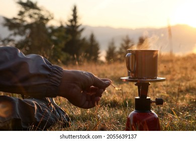 Man Making Hot Drink With Portable Gas Burner In Mountain Camping, Closeup