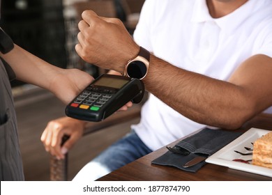 Man Making Payment With Smart Watch In Cafe, Closeup