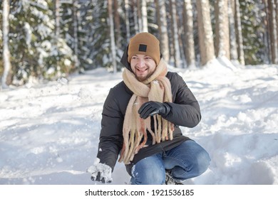 Man Making Snowball In Snowy Forest.