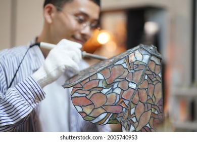 A Man Making A Stained Glass Lamp 
