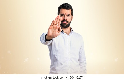 Man Making Stop Sign Over Ocher Background