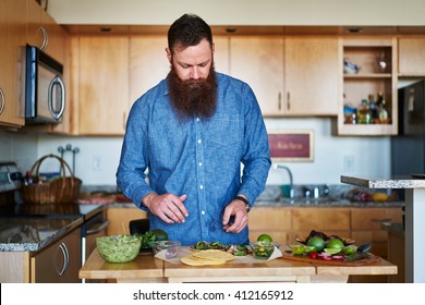 Man Making Tacos At Home In The Kitchen