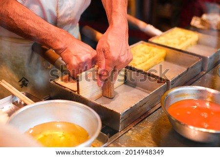 Man making tamago yaki, japanese omelette style, Japanese sweet egg roll