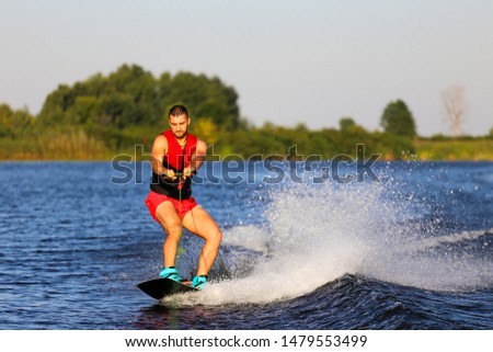 Man making waves on wakeboard 