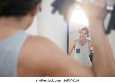 Man Making A Workout With A Dumbbells And Looking In A Mirror