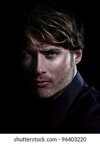 Man - male beauty portrait on black background. Young Caucasian man staring serious close up.