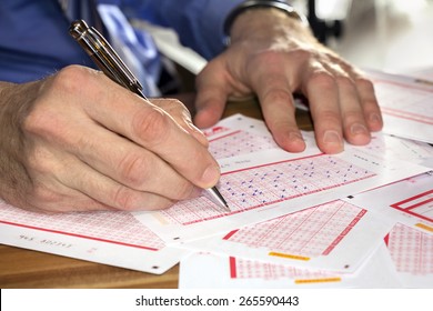 Man Marking on lottery ticket with a pen