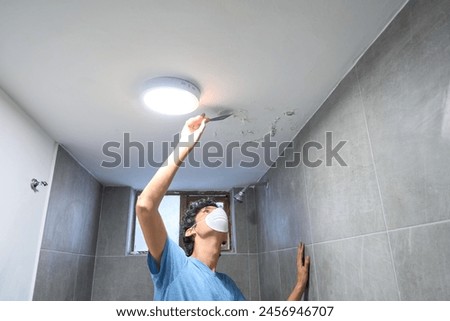 Man with mask in front of wall and ceiling with mold and saltpeter